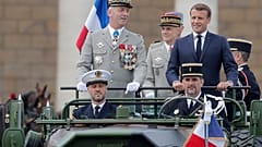 France's President Emmanuel Macron stands in the command car as he reviews troops before the start of the Bastille Day parade. 14 July, 2020.
