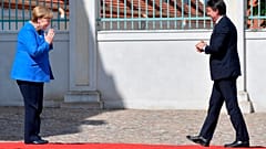 German Chancellor Angela Merkel, left, welcomes Italian Prime Minister Guiseppe Conte, right, for a meeting at the German government's guest house 'Meseberg' in Gransee