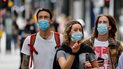 Shoppers wearing protective face masks walk along Oxford Street in London, Tuesday, July 14, 2020.