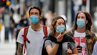 Shoppers wearing protective face masks walk along Oxford Street in London, Tuesday, July 14, 2020.