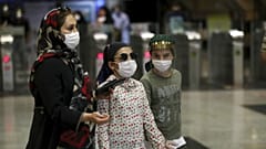 People wearing protective face masks to help prevent the spread of the coronavirus walk in a metro station, in Tehran, Iran