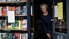 Jane Howe, owner of the Broadway Bookshop, poses for a photo in the doorway of her shop on Broadway Market in Hackney, east London on June 28, 2020 