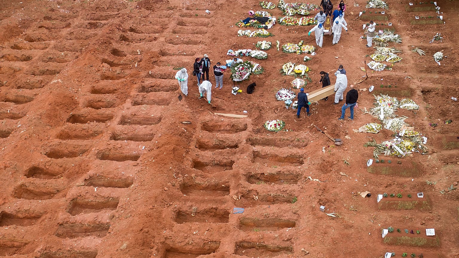 Cemetery workers in protective clothing bury three victims of the new coronavirus at the Vila Formosa cemetery in Sao Paulo, Brazil, Wednesday, July 15, 2020. 