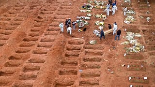 Cemetery workers in protective clothing bury three victims of the new coronavirus at the Vila Formosa cemetery in Sao Paulo, Brazil, Wednesday, July 15, 2020. 