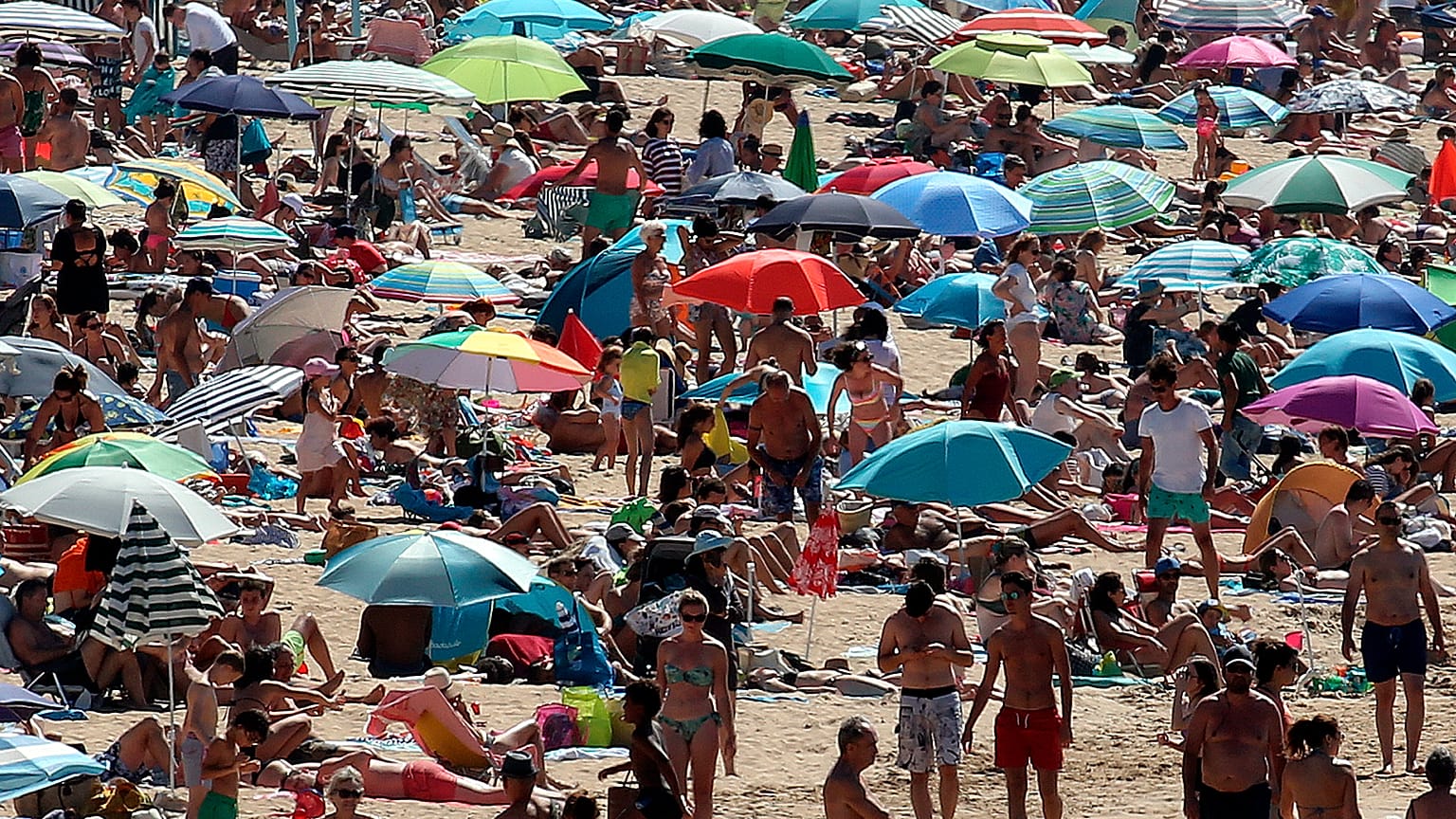 La gente toma el sol en la playa de San Juan de Luz, en el suroeste de Francia, el sábado 18 de julio.