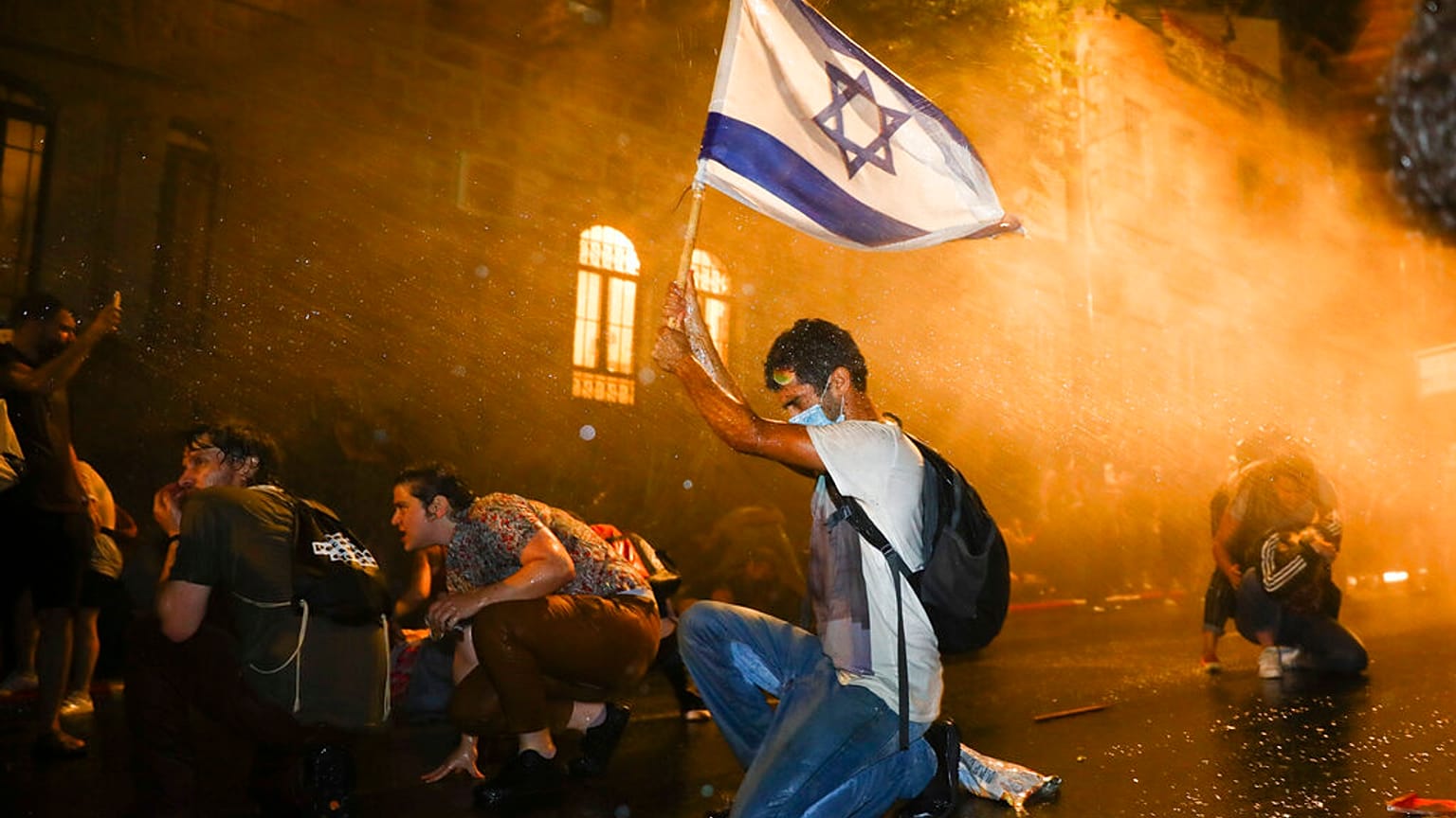 Israeli police use a water cannon to disperse people during a protest against Israeli Prime Minister Benjamin Netanyahu in Jerusalem, Saturday, July 18, 2020