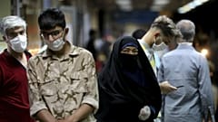 People wearing protective face masks to help prevent the spread of the coronavirus walk in a metro station, in Tehran, Iran