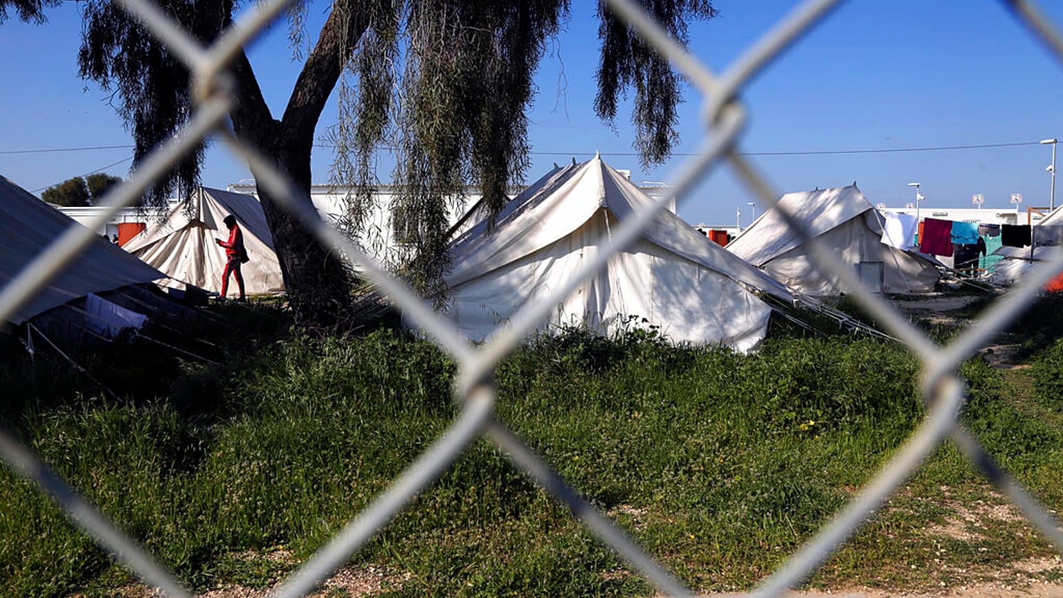 A migrant walks by the tents inside a refugee camp in Kokkinotrimithia outside of Nicosia, Cyprus, Tuesday, March 3, 2020.