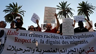 صورة من الأرشيف-ناشطون يرفعون لافتة وهم يتظاهرون ضد العنصرية أمام البرلمان المغربي في الرباط - المغرب 2014