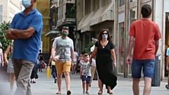 Una familia con mascarillas caminando por la calle