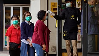 Customers receive temperature check at a restaurant in Hong Kong Tuesday, April 14, 2020.