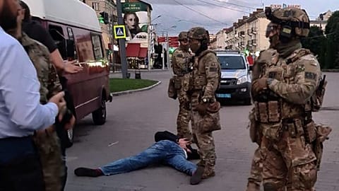 An assailant, who seized a bus with hostages, lies on the ground after police officers detained him in the city centre of Lutsk, some 400 kilometres west of Kyiv, Ukraine