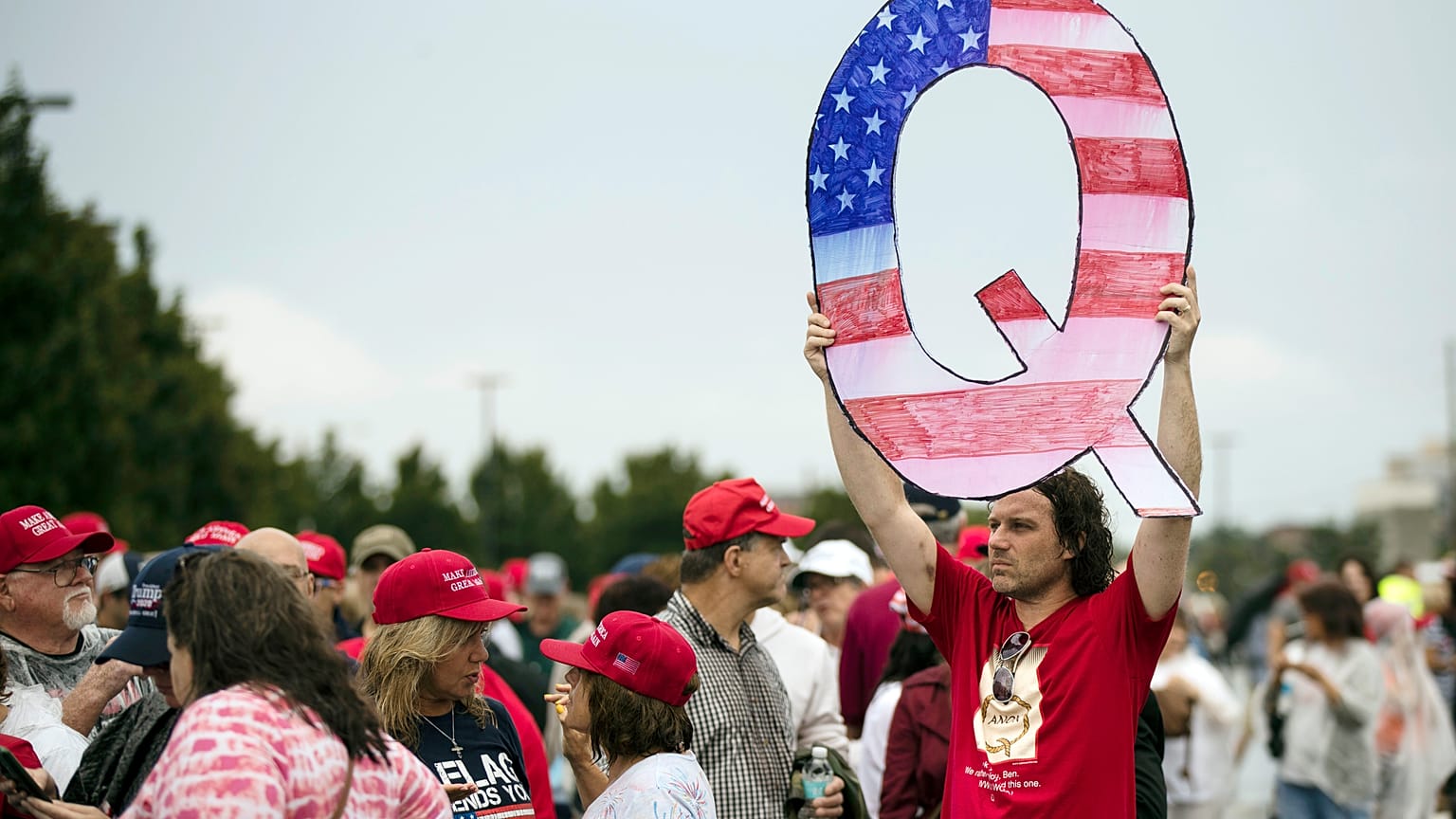 David Reinert holding a Q sign waits in line with others to enter a campaign rally with President Donald Trump and U.S. Senate candidate Rep. Lou Barletta, August 2018