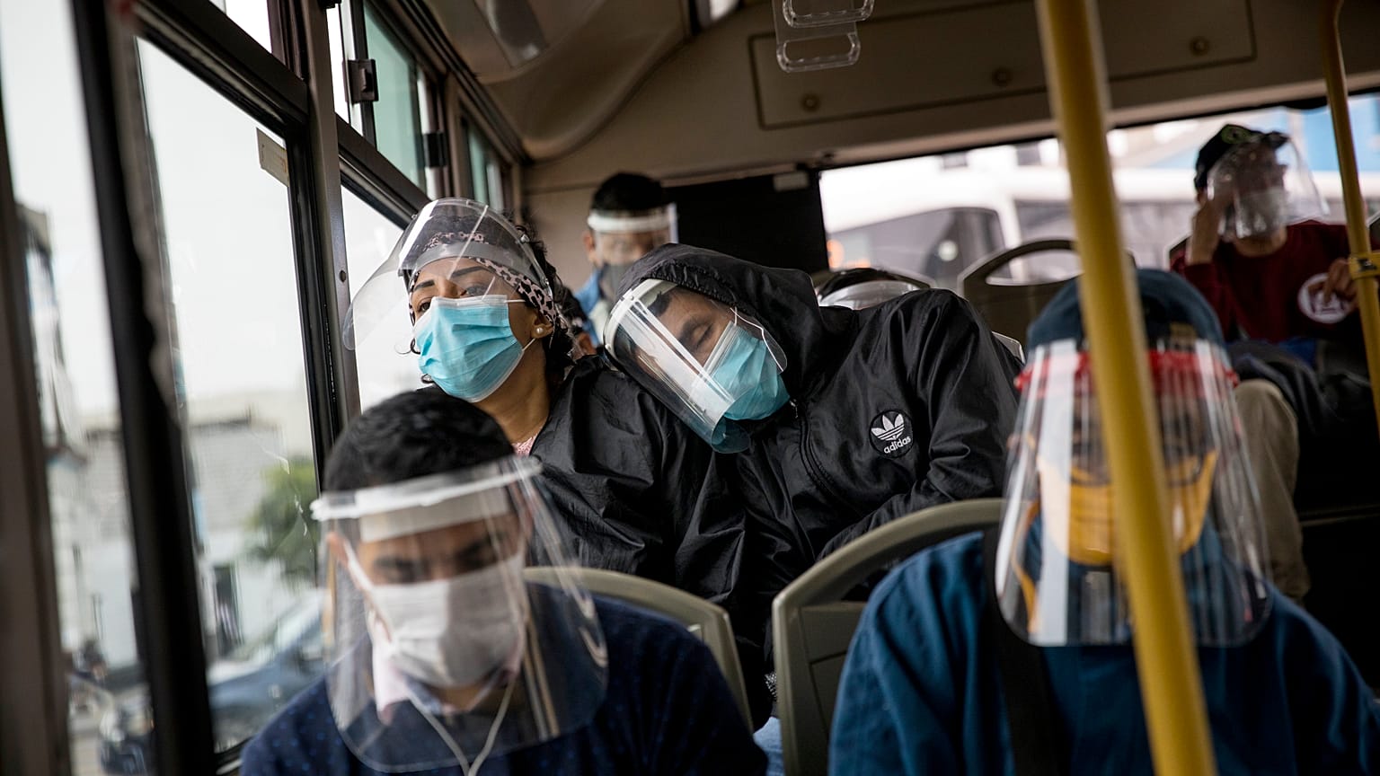 Commuters, wearing protective face masks and face shields, travel on a public bus in Lima, Peru, Wednesday, July 22, 2020.