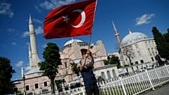 A man waves a Turkish flag outside the Hagia Sophia, following Turkey's decision to convert it into a mosque
