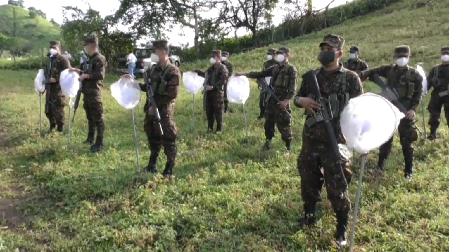 Un grupo de soldados recibe instrucciones antes de fumigar los campos