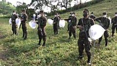 Un grupo de soldados recibe instrucciones antes de fumigar los campos