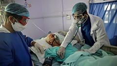medical workers attend to a COVID-19 patient in an intensive care unit at a hospital in Sanaa, Yemen.