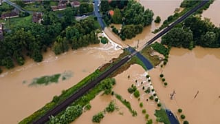 A nagy esőzés miatt vízzel elárasztott és megrongálódott út Zalaszentjakabon 2020. július 25-én. Középen a Budapest-Nagykanizsa vasútvonal része látható.