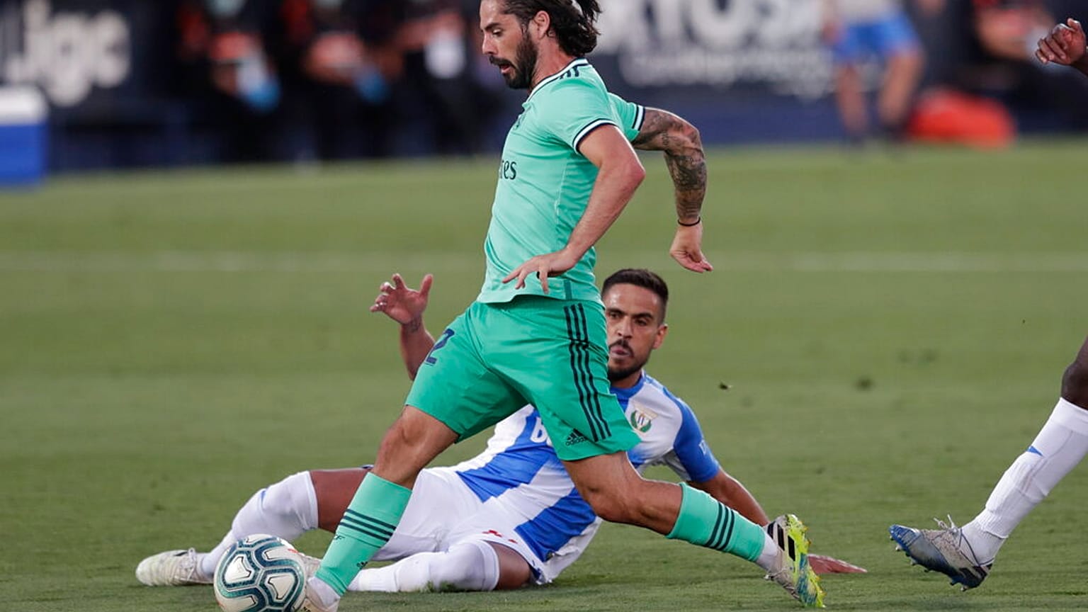 Real Madrid's Isco, is tackled by a Leganes' player during the Spanish La Liga soccer match between Leganes and Real Madrid.