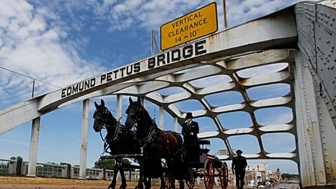 The casket of Rep. John Lewis moves over the Edmund Pettus Bridge by horse drawn carriage during a memorial service.