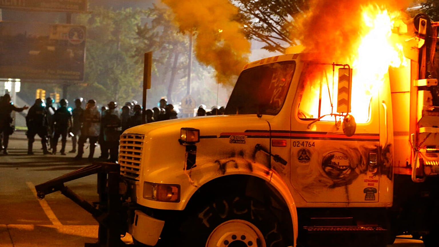 Police stand in front of a utility vehicle that was set on fire by protesters during a demonstration in Richmond, Virginia, July 25, 2020