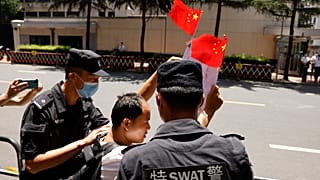 Policías detienen a un ciudadano que entonaba cánticos nacionalistas mientras agitaba banderas chinas frente al edificio del consulado de EEUU en Chengdu