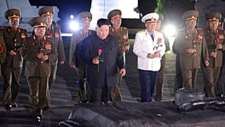 North Korean leader Kim Jong Un, center, with military officers in uniforms prepares to lay a flower to the Fatherland Liberation War Martyrs' Cemetery in Pyongyang.