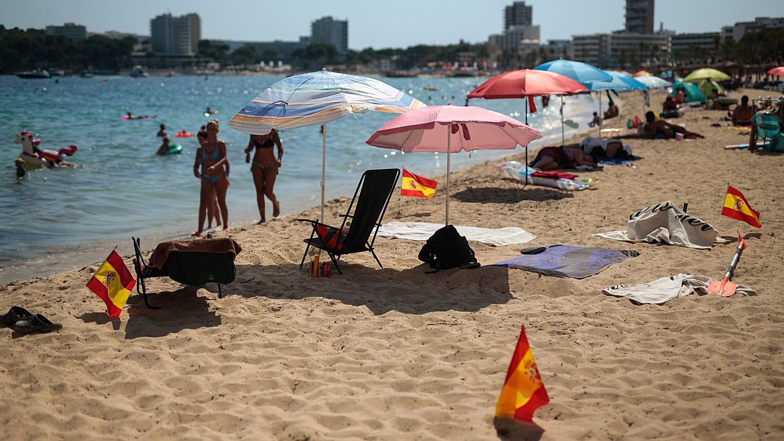 Las banderas españolas se usan como señal de distanciamiento social en la arena en Palma de Mallorca, España, el domingo 26 de julio de 2020. 