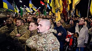 سربازان و داوطلبان اوکراینی که با جدایی‌طلبان جنگیده‌اند در حال رژه و حمل پرچم اوکراین 