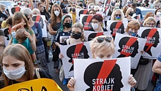 Protesters with a banner reading "Women's Strike" taking part in a rally against Polish government plans to withdraw from the Istanbul Convention on prevention and combatting