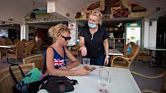 Una camarera atiende a una turista británica en Magaluf, Mallorca