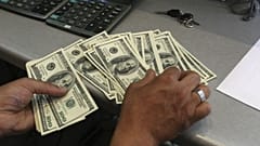 A currency exchange bureau worker, counts US dollars, in downtown Tehran, Iran