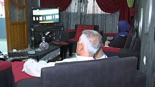 فؤاد أبو صافي وزوجته اعتدال أبو صافي يتابعان الحج عبر شاشة النلفاز من بيتهما في غزة