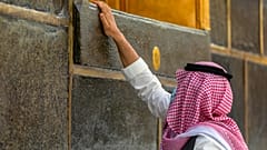 أحد المصلين يلمس جدار الكعبة 