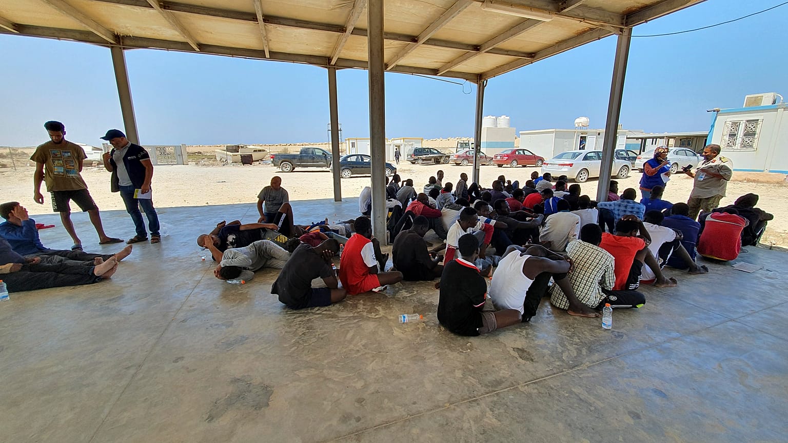 In this file photo from 2019, rescued migrants rest near the city of Khoms, around 120 kilometres east of Tripoli.