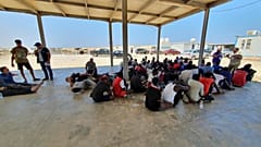 In this file photo from 2019, rescued migrants rest near the city of Khoms, around 120 kilometres east of Tripoli.