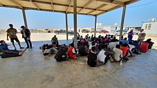 In this file photo from 2019, rescued migrants rest near the city of Khoms, around 120 kilometres east of Tripoli.