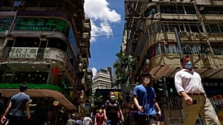 People wearing face masks to help curb the spread of the coronavirus walk on a downtown street in Hong Kong