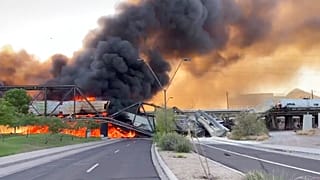 Smoke fills the sky at the scene of a train derailment in Tempe, Arizona