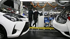 Employee wearing a face masks stand by the production chain of the Yaris car at the Toyota car factory in Onnaing, northern France