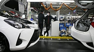 Employee wearing a face masks stand by the production chain of the Yaris car at the Toyota car factory in Onnaing, northern France