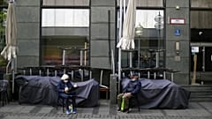 An elderly couple sit outside a closed bar in Munich, Germany