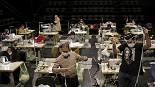 Volunteers wearing face masks to curb the spread of the new coronavirus, sew face masks for poor people, at the Hafez theatre hall in downtown Tehran, Iran