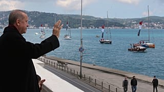O T. Ερντογάν χαιρετά πλοία διακοσμημένα με την τουρκική σημαία κατά τους εορτασμούς για την κατάκτηση της Κωνσταντινούπολης