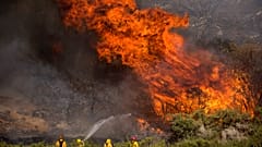 Firefighters work against the Apple Fire near Banning, Calif., Sunday, Aug. 2, 2020