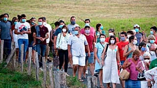 People wear face masks as they leave a music festival in Saint Etienne de Baigorry, southwestern France, Sunday, July 26, 2020.