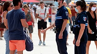 Des policiers français demandent aux passants de porter un masque, Biarritz, France, le 3 août 2020
