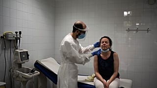 شابة تجري اختبار تحليل الإصابة بمرض كوفيد-19 في مركز الرعاية الصحية الأولية في منطقة كاتالونيا في إسبانيا.