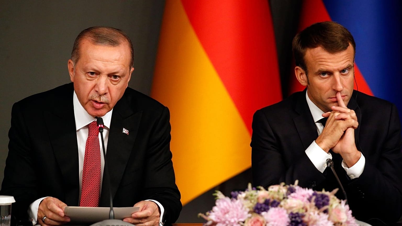Turkey's President Recep Tayyip Erdogan, left, sits by French President Emmanuel Macron during a news conference following a summit on Syria, in Istanbul, Saturday, Oct. 27, 2